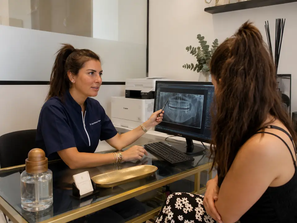 Le Dr Laura Zeitoun Saal à son bureau, commentant une radiographie panoramique à l’écran